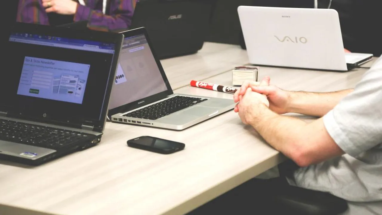 A business meeting around a laptop, two people reviewing a website and its search performance together